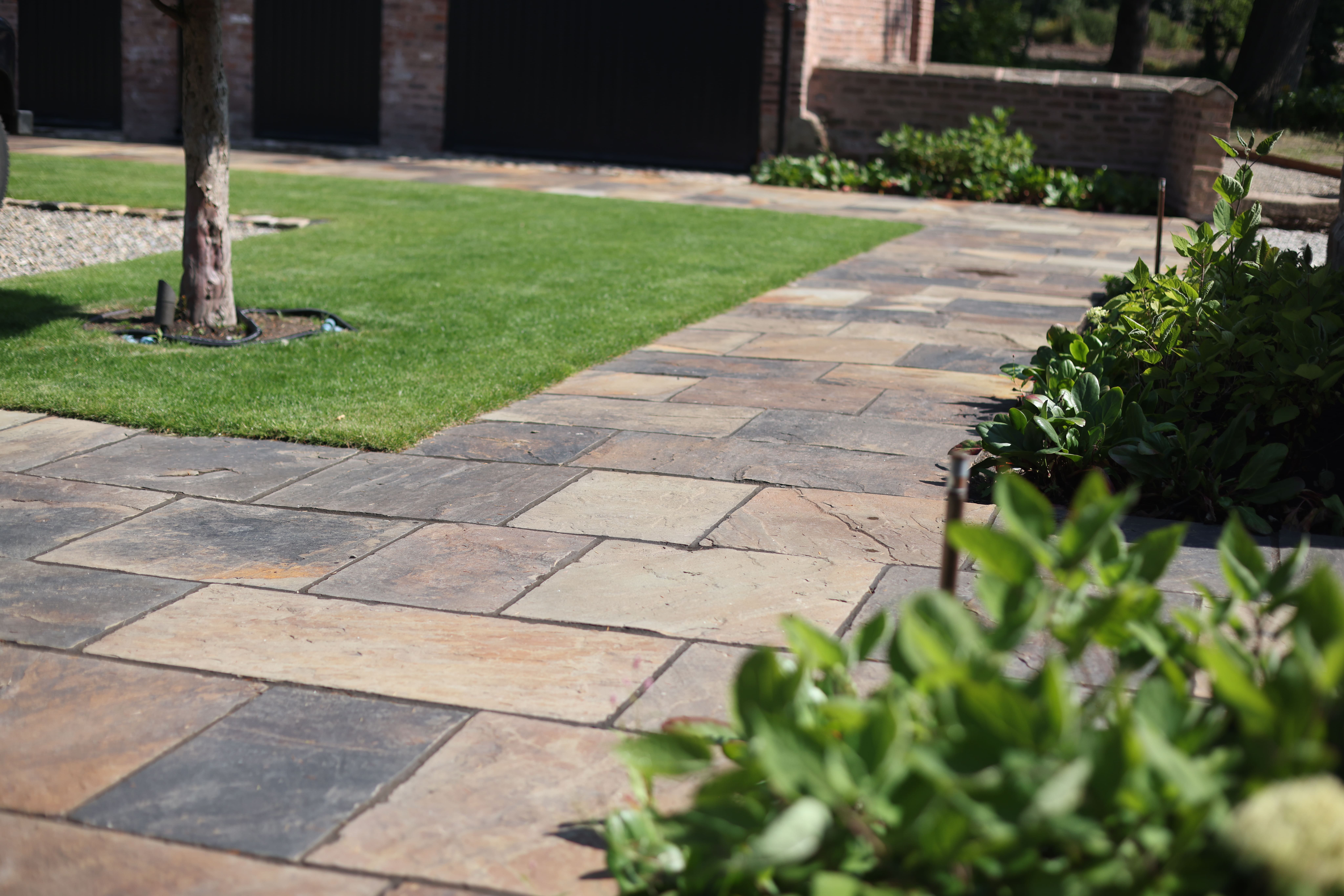 Lyons Stonework installing British riven paving, delivering natural texture and rustic elegance for outdoor designs.