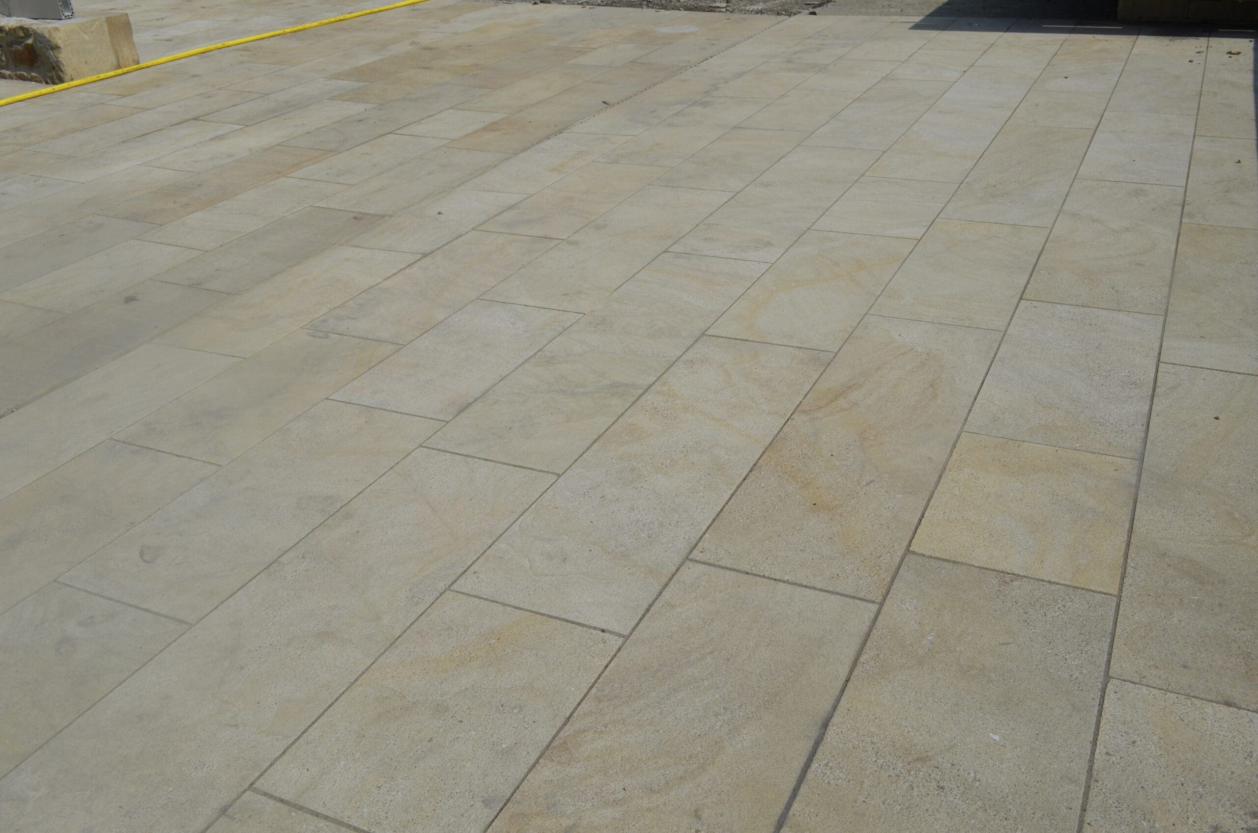 Close-up of Fletcher Bank sandstone paving, showcasing smooth, natural stone slabs with subtle variations in color and texture.