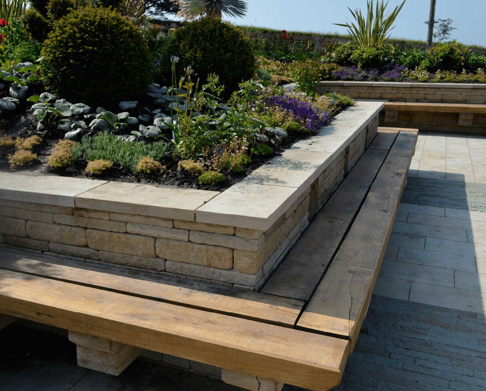 Close-up of stone benches seamlessly extending from a natural stone wall, blending practicality with the aesthetics of the wall.
